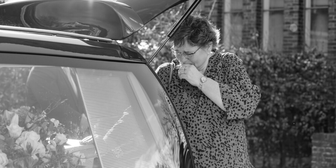 laatste handlegging op kist door verdrietige vrouw